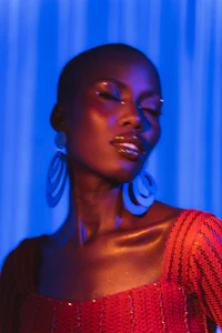 a woman in a red dress posing in front of a blue light